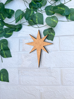 DIY MDF star cutout for Christmas craft mounted on white brick wall