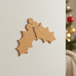 DIY MDF holly leaves cutout with berries for Christmas craft mounted on white wall