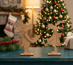 MDF DIY reindeer figures on a table with a Christmas tree and stockings in the background.