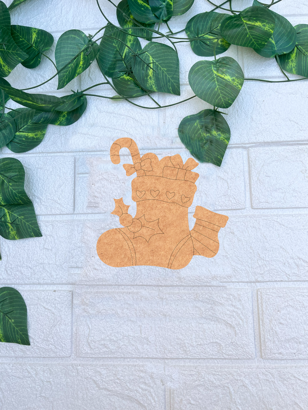 DIY MDF Christmas stocking cutout for Christmas craft mounted on white brick wall