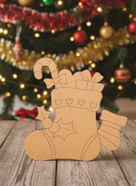 DIY MDF Christmas stocking cutout for Christmas craft standing on wooden table 