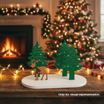 Decorative Christmas scene with trees and a deer on a wooden table, fireplace, and tree in the background.