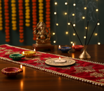 Decorative table setting with lit candles, a statue, and incense sticks on a red cloth with mdf tealight candle holder.