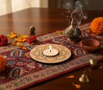 Decorative setup with a lit candle, incense burner, and marigold flowers on a patterned cloth with mdf tealight candle holder.