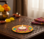 Decorative candle holder with a lit candle on a table with flowers and other decorations with handpainted mdf tealight candle holder.