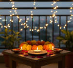 Decorative setup with marigold flowers and candles on a table at night, illuminated by string lights with mdf tea light candle holder