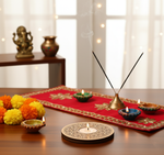Decorative setup with candles, incense sticks, and marigold flowers on a table with mdf tealight candle holder.