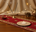 Decorative setting with incense sticks, candles, and a red cloth on a wooden surface with mdf tea light candle holder.