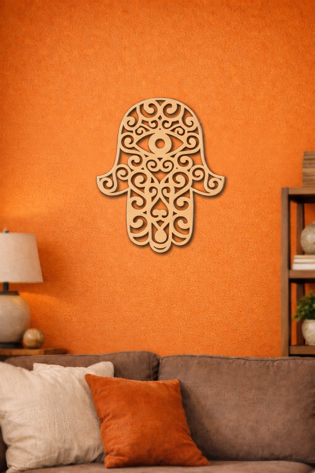 Decorative  MDF DIY  Hamsa wall art on an orange wall with a couch and lamp in the foreground.