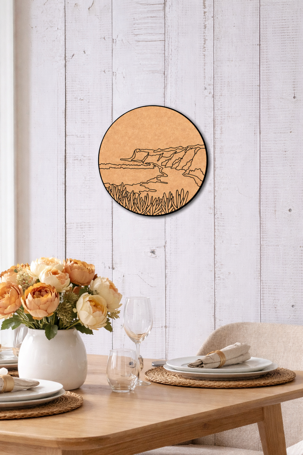 Decorative wall art above a table with a floral arrangement and glasses.