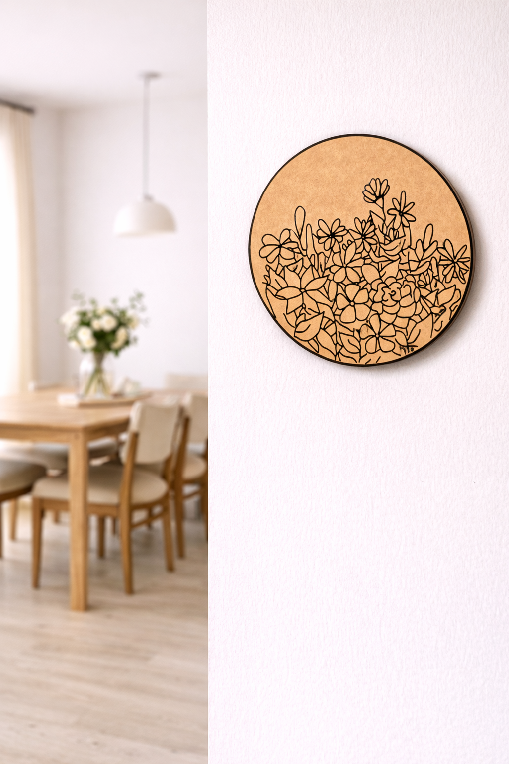 Decorative MDF DIY wall art with floral pattern on a white wall in a room with a wooden table and chairs.