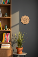 MDF feet design round wall art on gray wall near bookshelf and plant.