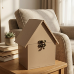 MDF Hut Shaped Piggy Bank on a wooden table with a cozy living room background