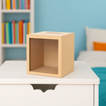 Empty MDF piggy bank box placed on white table in bedroom.