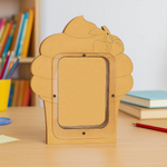 DIY MDF cupcake shaped Money bank on a wooden surface with books and stationery in the background.