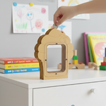 Hand inserting coin into plain MDF cupcake-shaped coin bank.