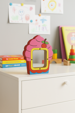 Brightly painted cupcake-shaped coin bank with cherry design on cabinet.