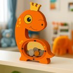 Orange DIY MDF dinosaur-shaped money box with a crown on a shelf