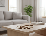 Minimal MDF paisley coaster centerpiece on wooden coffee table in modern living room.
