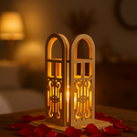 Decorative mdf lantern with intricate designs, emitting a warm glow, surrounded by red rose petals on a blurred background.