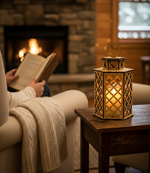 MDF lantern with candle beside reader near fireplace.