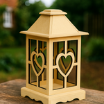 Decorative lantern with heart designs on a wooden surface outdoors