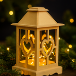 Wooden lantern with heart designs and string lights against a dark background
