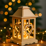 Decorative lantern with heart designs on a wooden surface with blurred lights in the background