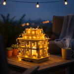 Decorative lantern with string lights on a table outdoors at night