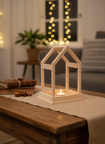 MDF house-shaped tealight holder on rustic table with festive lights in background
