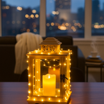 Decorative lantern with string lights and a candle on a table in a room with a cityscape view.