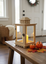 MDF lantern with glowing candle on entryway table with pumpkins and leaves