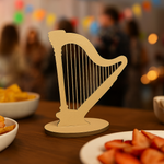 Minimal MDF harp décor on wooden table with party food