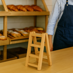 MDF step stool on a table with a bakery display in the background