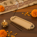 MDF incense holder with burning stick near Ganesha idol.