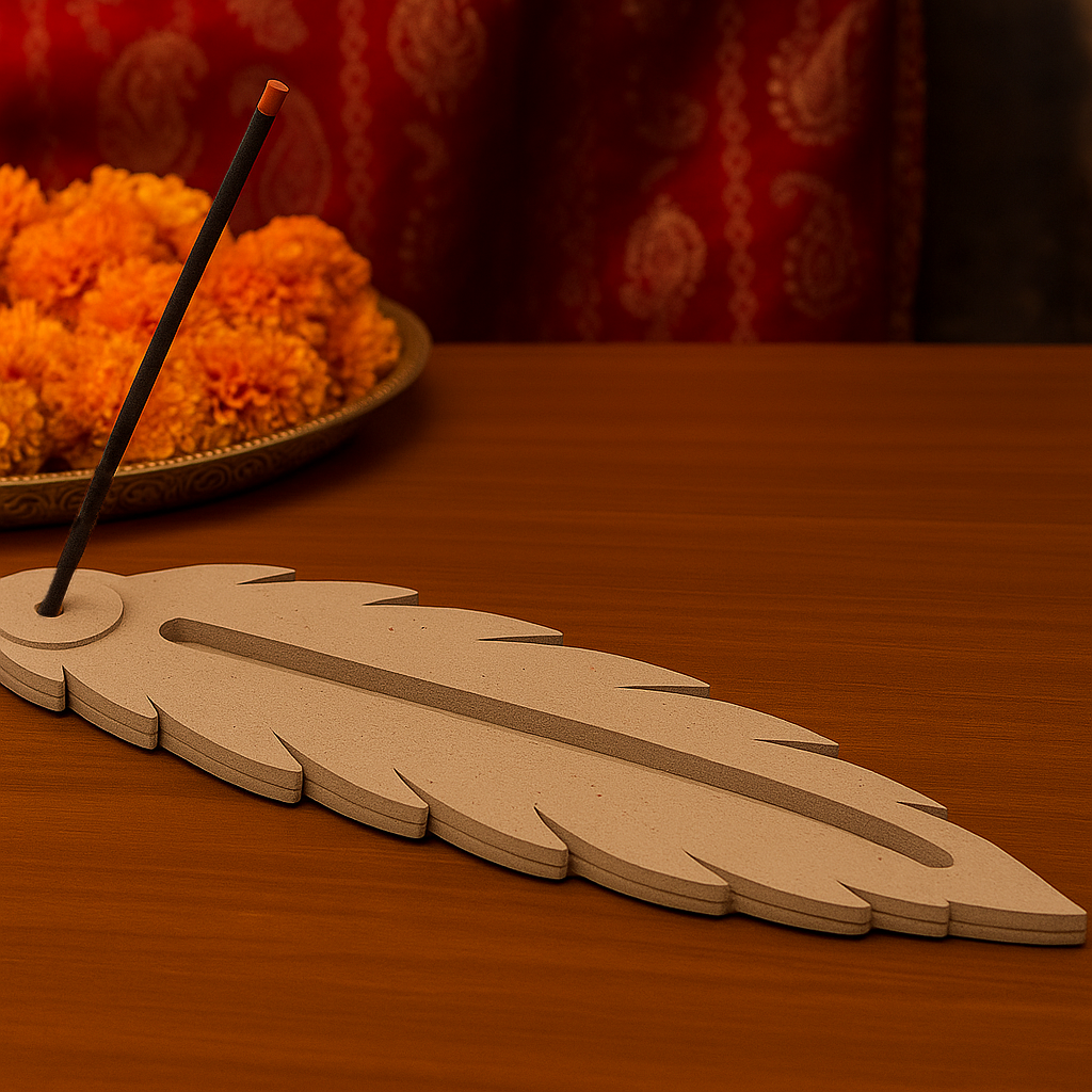 Decorative MDF feather incense holder with unlit incense stick and marigold flowers.
