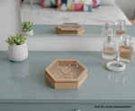 Hexagonal jewellery box with 'LOVE' engraving on a reflective surface with decorative items.