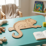 MDF DIY  Iguana toy on a teal table with books and stuffed animals in the background