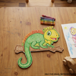 Colorful MDF DIY  Iguana on a wooden table with crayons and a child's drawing.