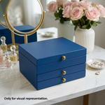 Blue MDF DIY  jeweIlery box with gold knobs on a marble surface, surrounded by decorative items.
