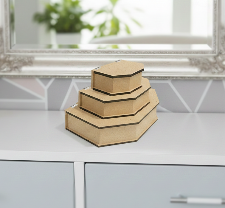Set of three hexagonal  MDF DIY  jewellery boxes on a white surface with a blurred background