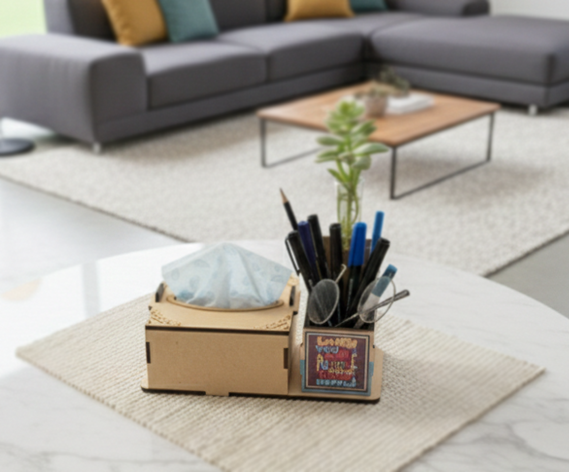 A  MDF DIY desk organizer and tissue box holder sits on a round table in a modern living room setting. The organizer features a natural wood grain finish, a clear plastic tissue slot on the left, and a pen cup on the right with a colorful 'Sakura Wood Products' logo sticker.