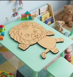 Children's play area with a MDF DIY lion-shaped cutout on a green table, surrounded by books and toys.