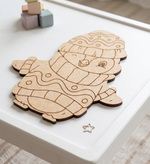 MDF DIY penguin cutout on a white surface with colorful blocks in the background