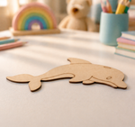 MDF DIY dolphin toy on a light surface with colorful items in the background