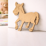 MDF DIY horse cutout on a white surface with a teddy bear in the background