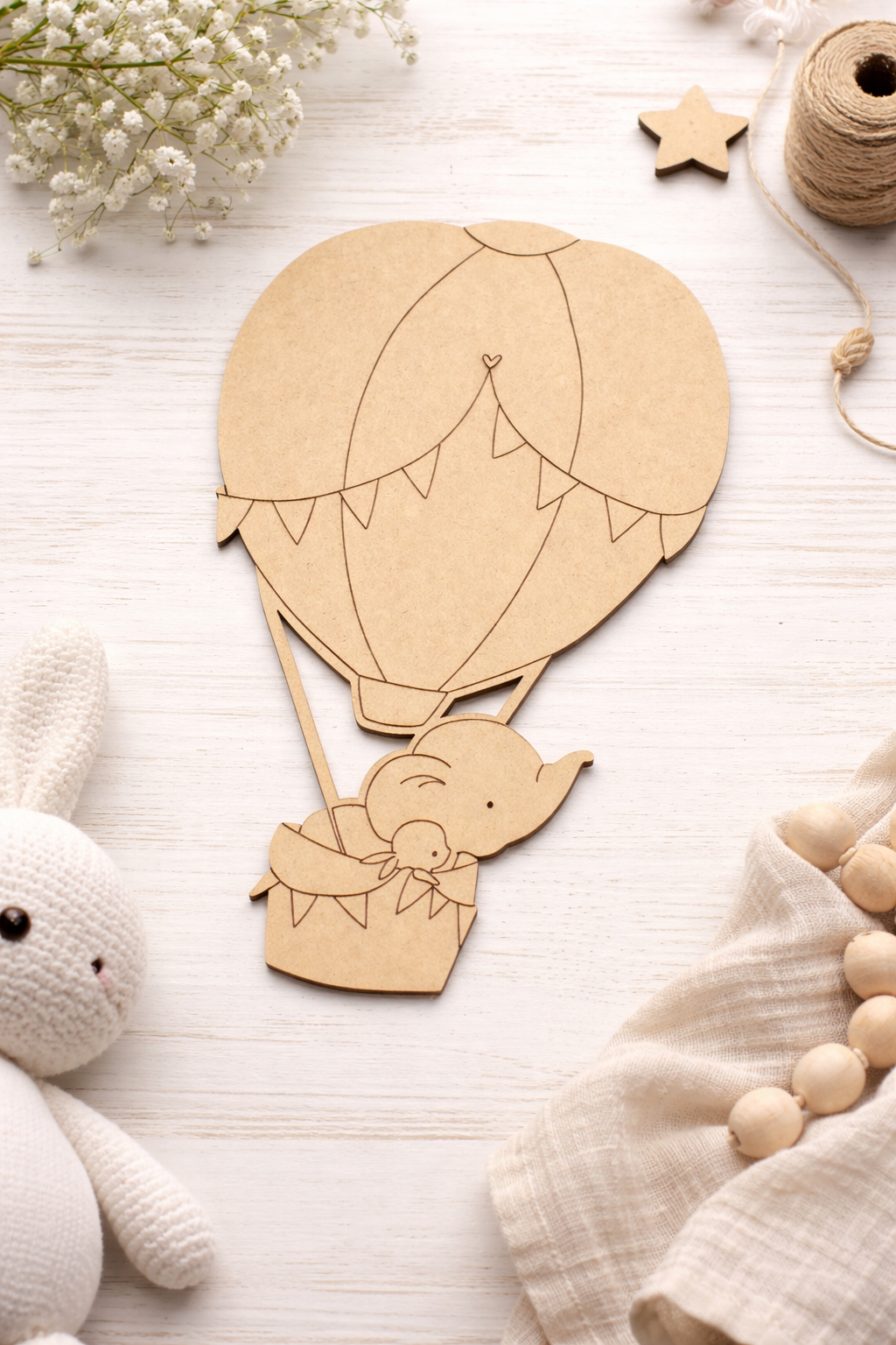MDF DIY hot air balloon toy with a baby design on a light wooden surface with decorative items.
