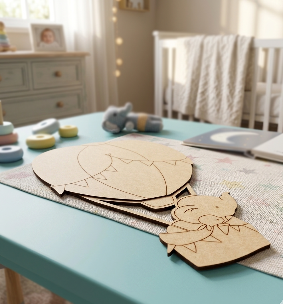 MDF DIY elephant cutouts on a table in a nursery with toys and a crib in the background.