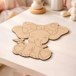 MDF DIY cutout of an elephant with a bow on a white surface