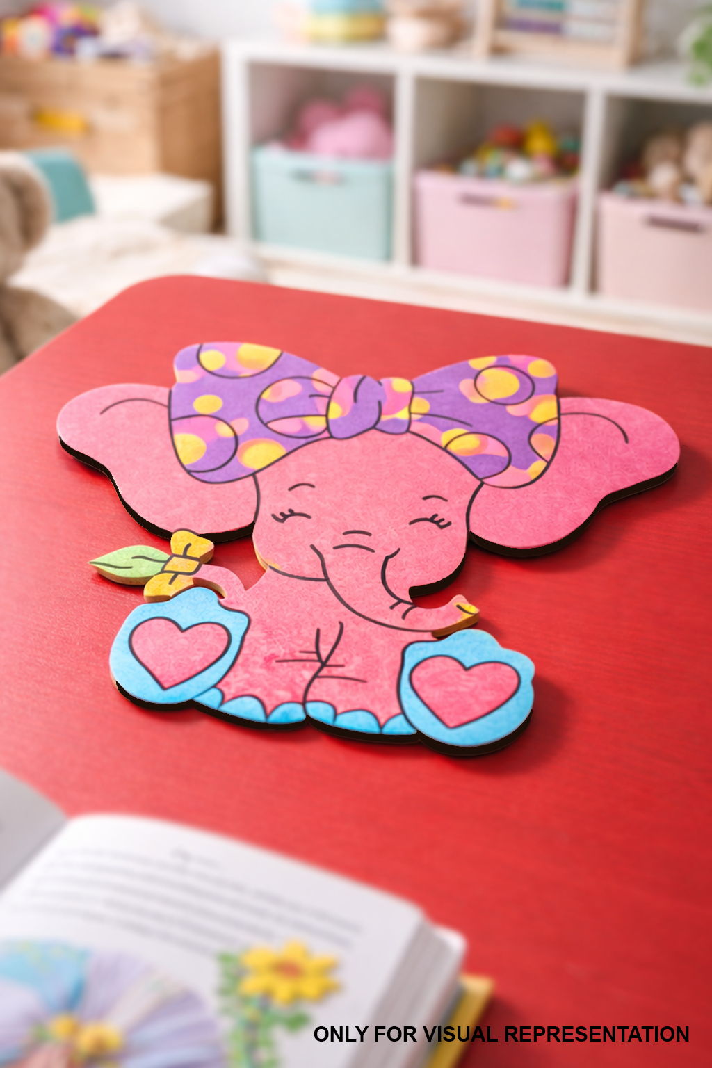 Colorful MDF DIY elephant cutout with a bow on a red table in a playroom setting.